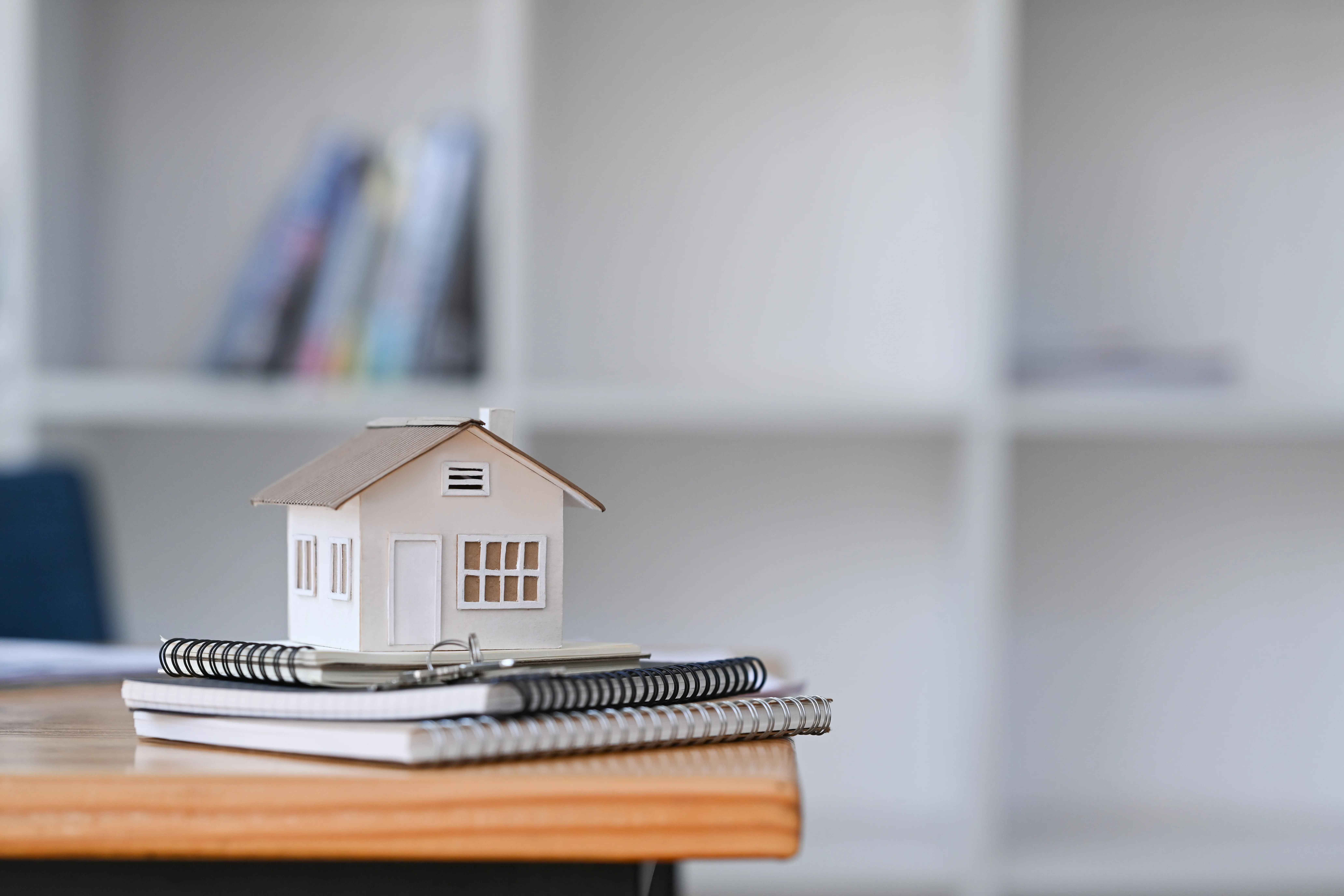 Hausmodell auf einem Tisch – Symbol für den Immobilienverkauf